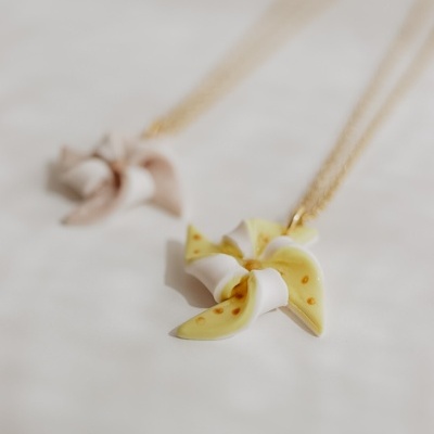 Colares com pendentes em forma de catavento amarelo claro e bege