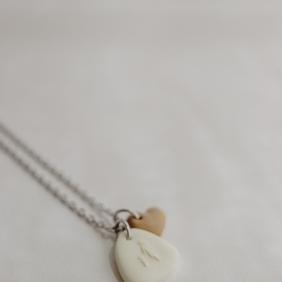 Colar com pedras pendentes branca e castanha claro em fundo branco