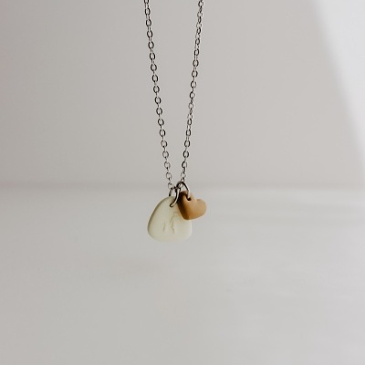 Colar com pendentes bege e castanho claro em fundo branco