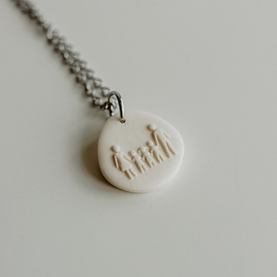 Colar com pendente redondo branco com figuras de família em relevo