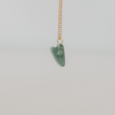 Colar dourado com pendente verde em forma de coração com dente-de-leão