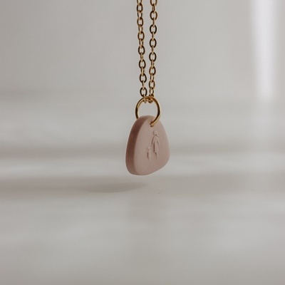 Colar com pendente rosa claro pendurado em corrente dourada