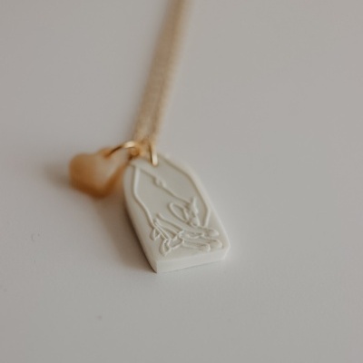 Colar dourado com pendente branco gravado e pendente dourado em forma de coração
