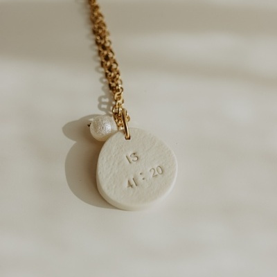 colar dourado com pendente branco gravado IS 41:20 e bola perolada