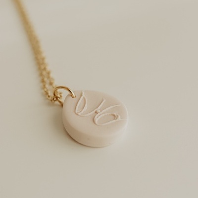 Colar com pendente oval bege e corrente dourada