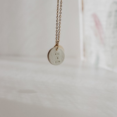 Colar pendente redondo creme claro com letras ATE A LUA em corrente dourada