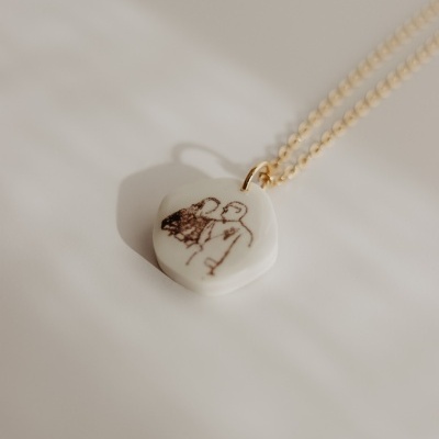 Colar com pendente branco e desenho de casal com corrente dourada