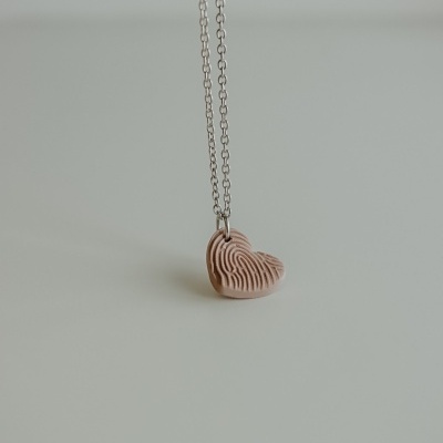 Colar com pendente em forma de coração rosa com padrão de digital