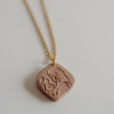 Colar pendente quadrado terra com relevo figura feminina em corrente dourada