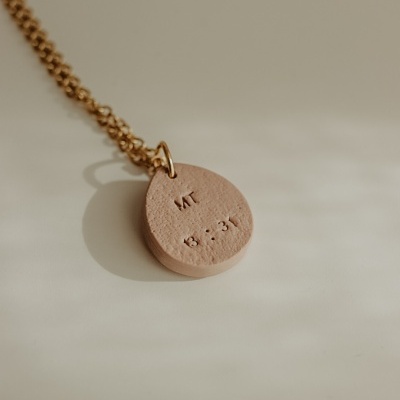 Colar com pendente oval cor de bege e corrente dourada