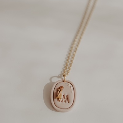 Colar com pendente oval creme e corrente dourada