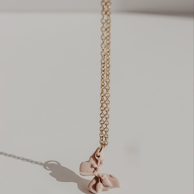 Colar dourado com pendente laço rosa