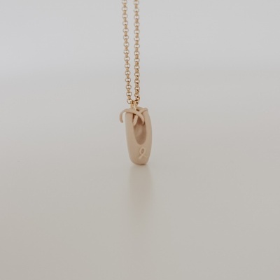 Colar dourado com pendente em forma de mini sapatilha de ballet