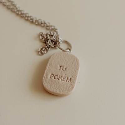 Colar com pendente em pedra ou cerâmica bege gravado com texto e corrente prateada