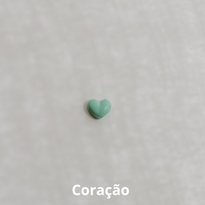 Pequeno coração verde sobre fundo branco texturizado