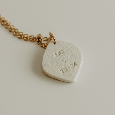 Colar com pendente branco texturizado e gravação em relevo