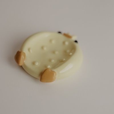 Placa decorativa creme com detalhes castanhos em fundo branco