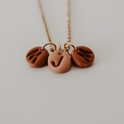 Colar dourado com três pendentes redondos castanhos e bege