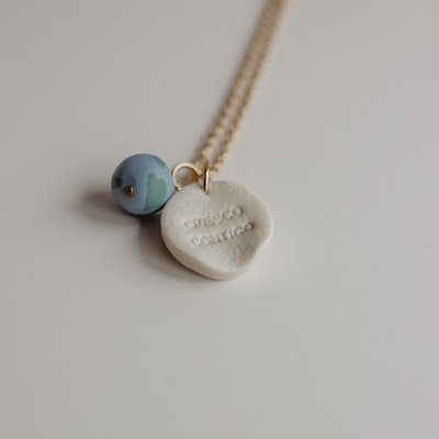 Colar dourado com pendente coração branco e conta azul