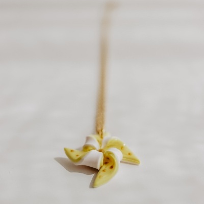 Colar com pendente em forma de pinhão branco e amarelo com manchas castanhas