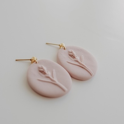 Brincos ovais rosa com relevo floral e fecho dourado