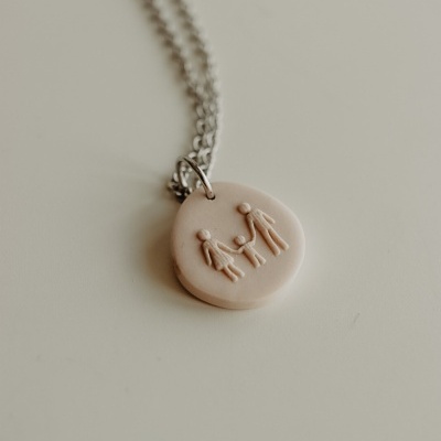 Colar com pendente redondo bege com relevo de família e corrente prateada