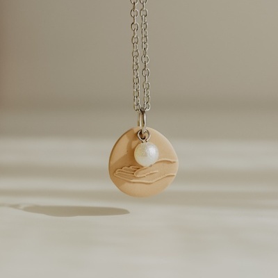 Colar com pendente redondo bege e bola perolada em corrente prateada