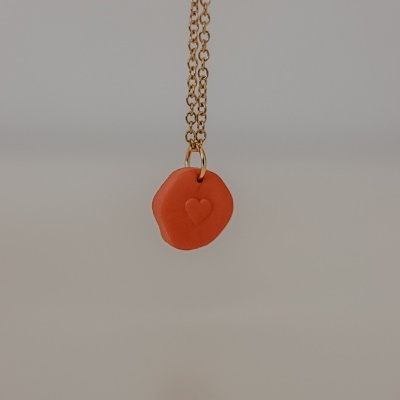 Colar com pendente vermelho em forma de selo com coração em relevo