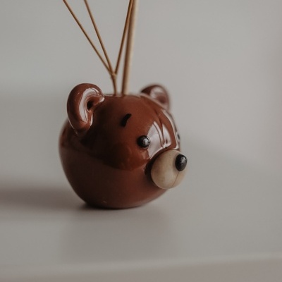 Vaso em cerâmica castanha em forma de cabeça de ursinho com flores secas