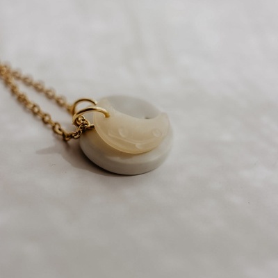Colar dourado com pendentes branco redondo e lua crescente translúcida