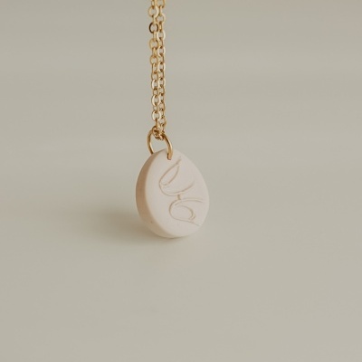 Colar com pendente redondo creme com gravação abstrata