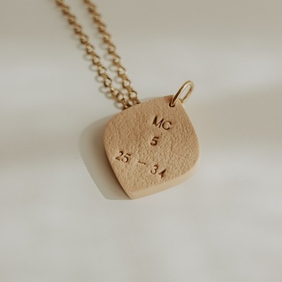 Colar com pendente bege e corrente dourada