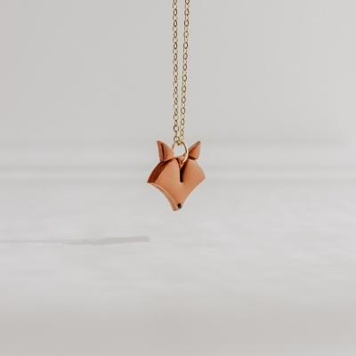 Colar de raposa em couro castanho com corrente dourada sobre fundo cinza claro