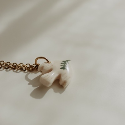 Colar com pendente branco em forma de pássaro com detalhe verde
