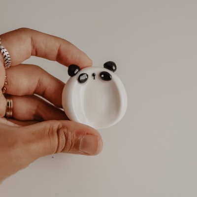 Figura miniatura redonda de panda branca e preta na mão