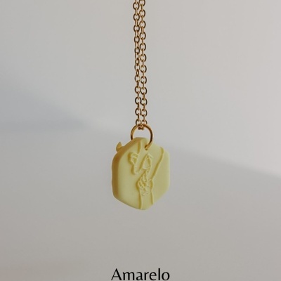 Colar dourado com pendente amarelo e relevo de figura humana