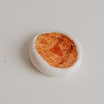 Disco redondo branco com pintura castanha no centro