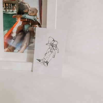 Fotografia a cores de duas crianças e papel com desenho a tinta sobre superfície clara