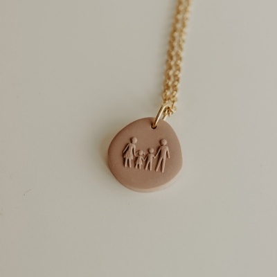 Colar com pendente redondo castanho claro e relevo de quatro figuras humanas