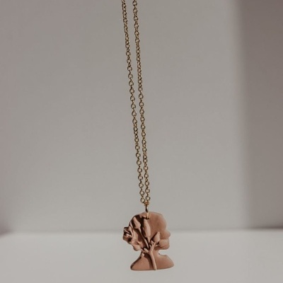 Colar com pendente em forma de silhueta de mulher rosa claro e corrente dourada