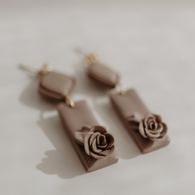 Brincos castanhos pendentes com flores em relevo