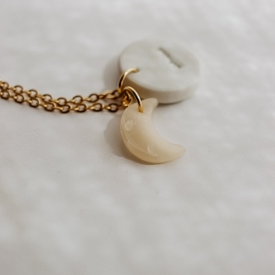 Colar com pendente de lua em tom creme sobre fundo branco