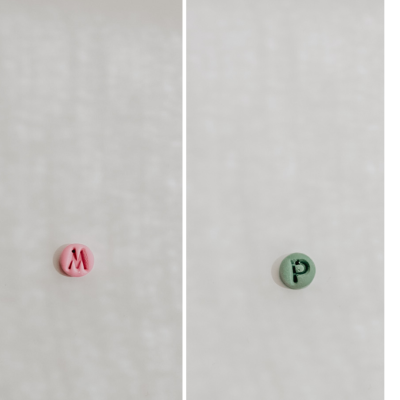 Botões rosa com letra M e verde com letra P em fundo branco, texto Rosa e Verde