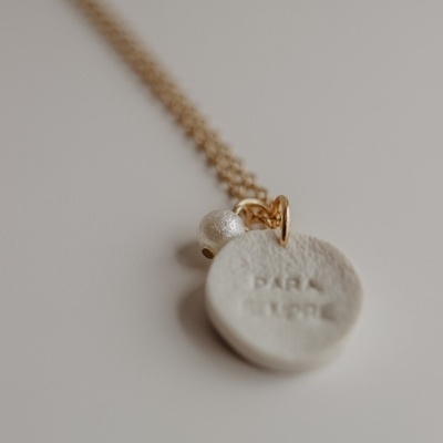 Colar dourado com pendente branco redondo e pérola