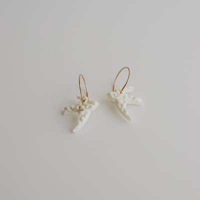 Brincos de pássaros brancos com argolas douradas sobre fundo branco