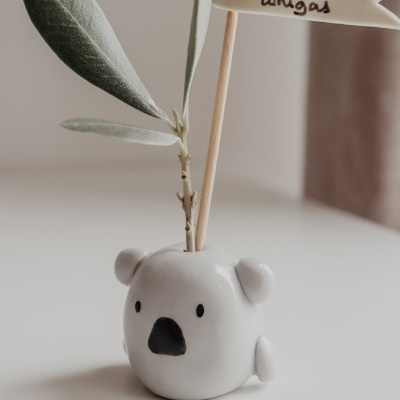 Vaso cerâmico em forma de coala com ramo e bandeira com texto em português