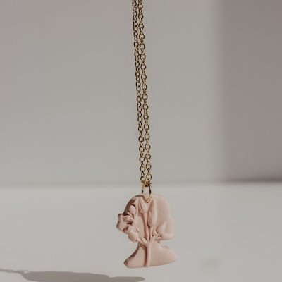 Colar com pendente rosa claro em forma de cabeça feminina abstrata