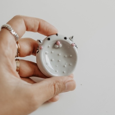 Pequeno prato de cerâmica branca decorado como rosto de gato com textura pontilhada