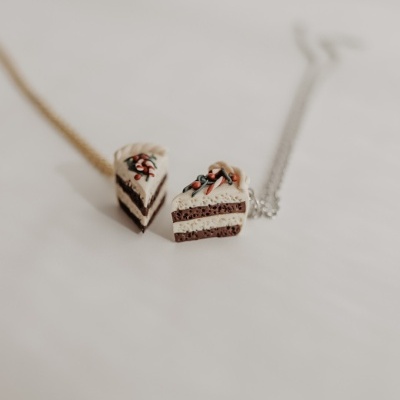 Colares com pendentes em forma de fatias de bolo sobre fundo branco