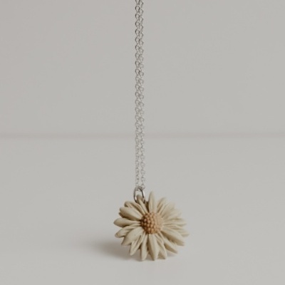 Colar com pendente de flor branca em fundo neutro